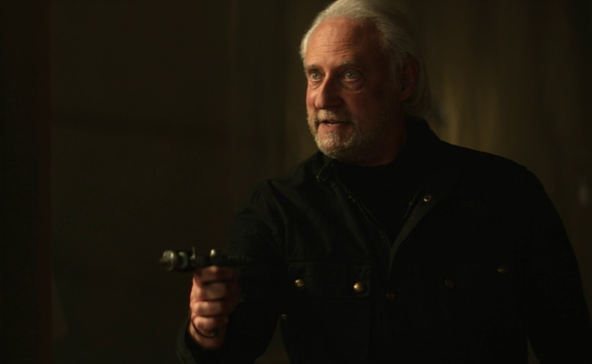 Still frame from Star Trek: Picard showing Adam Soong wielding a pistol.