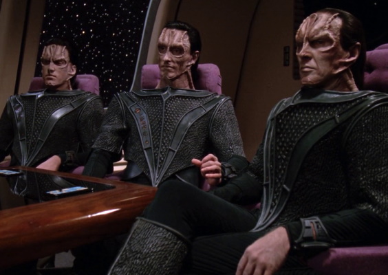 Still frame from Star Trek: The Next Generation (Chain of Command) showing three Cardassians sat at the Enterprise-D's briefing room table.