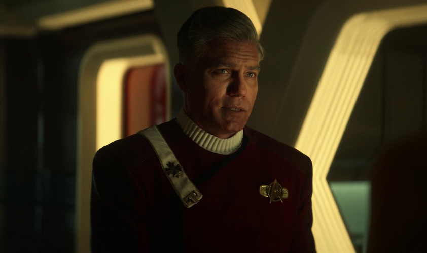 Still frame from Star Trek: Strange New Worlds Season 1 showing a future Captain Pike in a 'monster maroon' uniform.