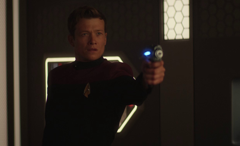 A still frame from "The Last Generation," the series finale of Star Trek: Picard, showing Jack Crusher wielding a phaser pistol.