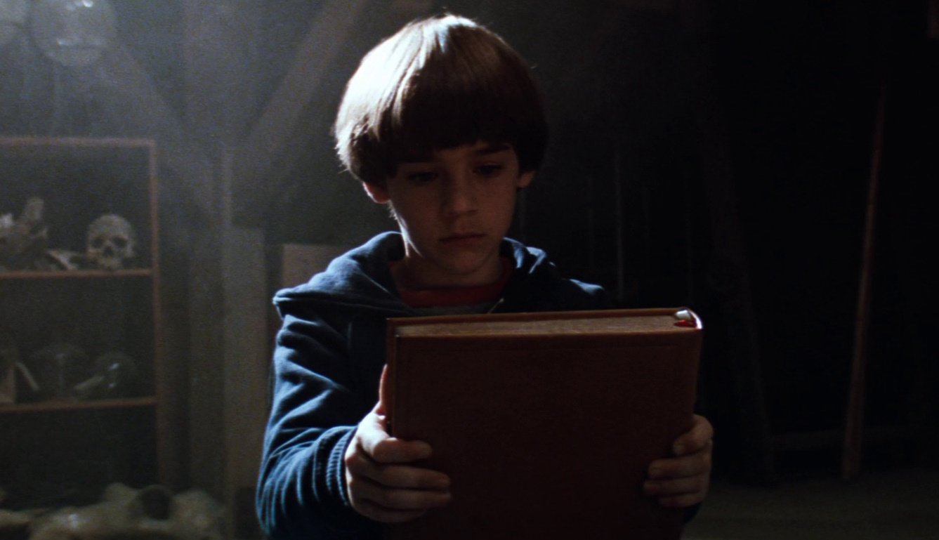 Still frame from The NeverEnding Story showing a child and a book