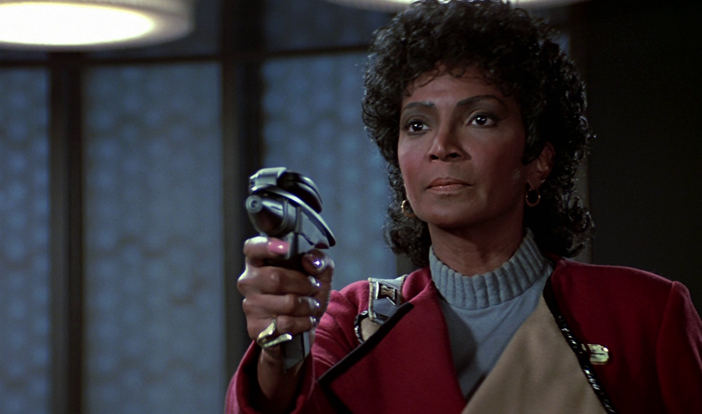 Still frame from Star Trek III: The Search for Spock showing Uhura wielding a phaser pistol.