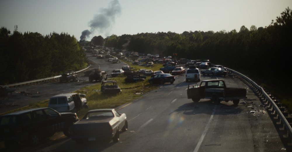 Still frame from Civil War showing abandoned vehicles.