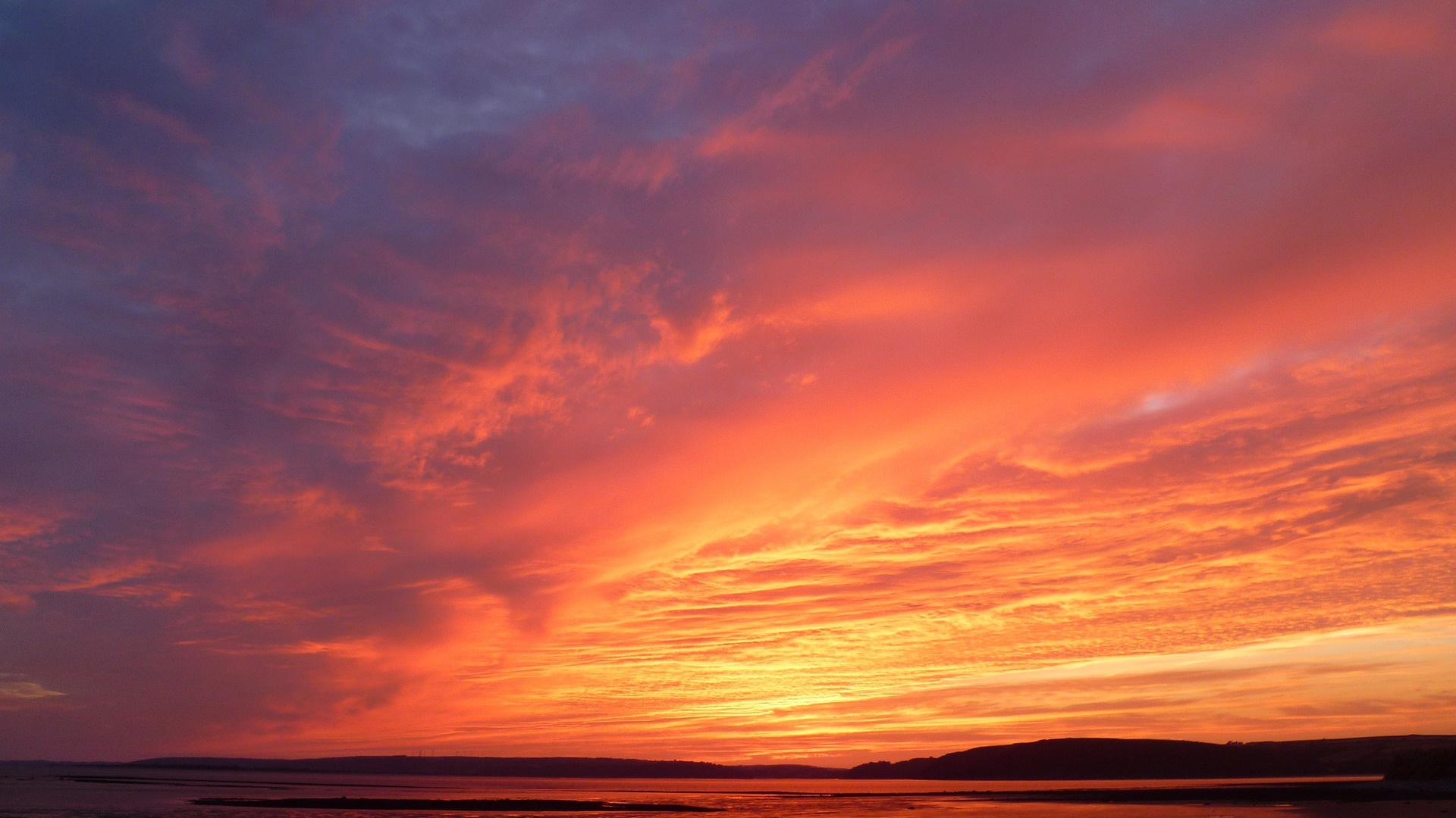 A stock photograph of a sunset over a coast or lake.