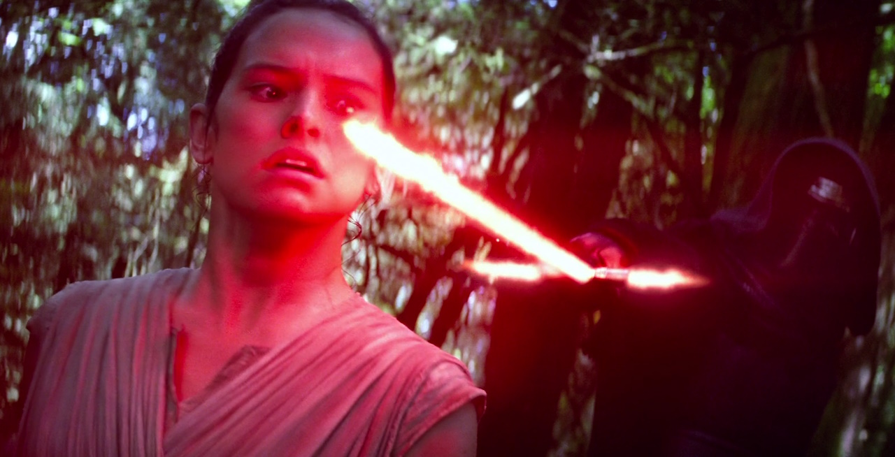 Still frame from The Force Awakens (2015) showing Kylo Ren holding a lightsaber to Rey's neck.