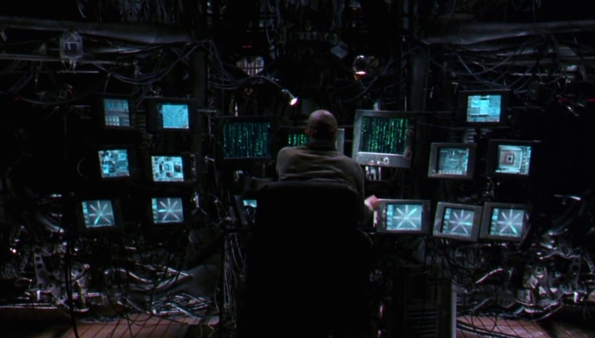 Still frame from The Matrix (1999) showing computer monitors and code.