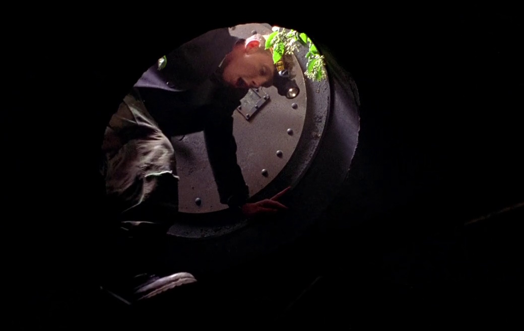 Still frame from The Hole (2001) showing a character entering the bunker.