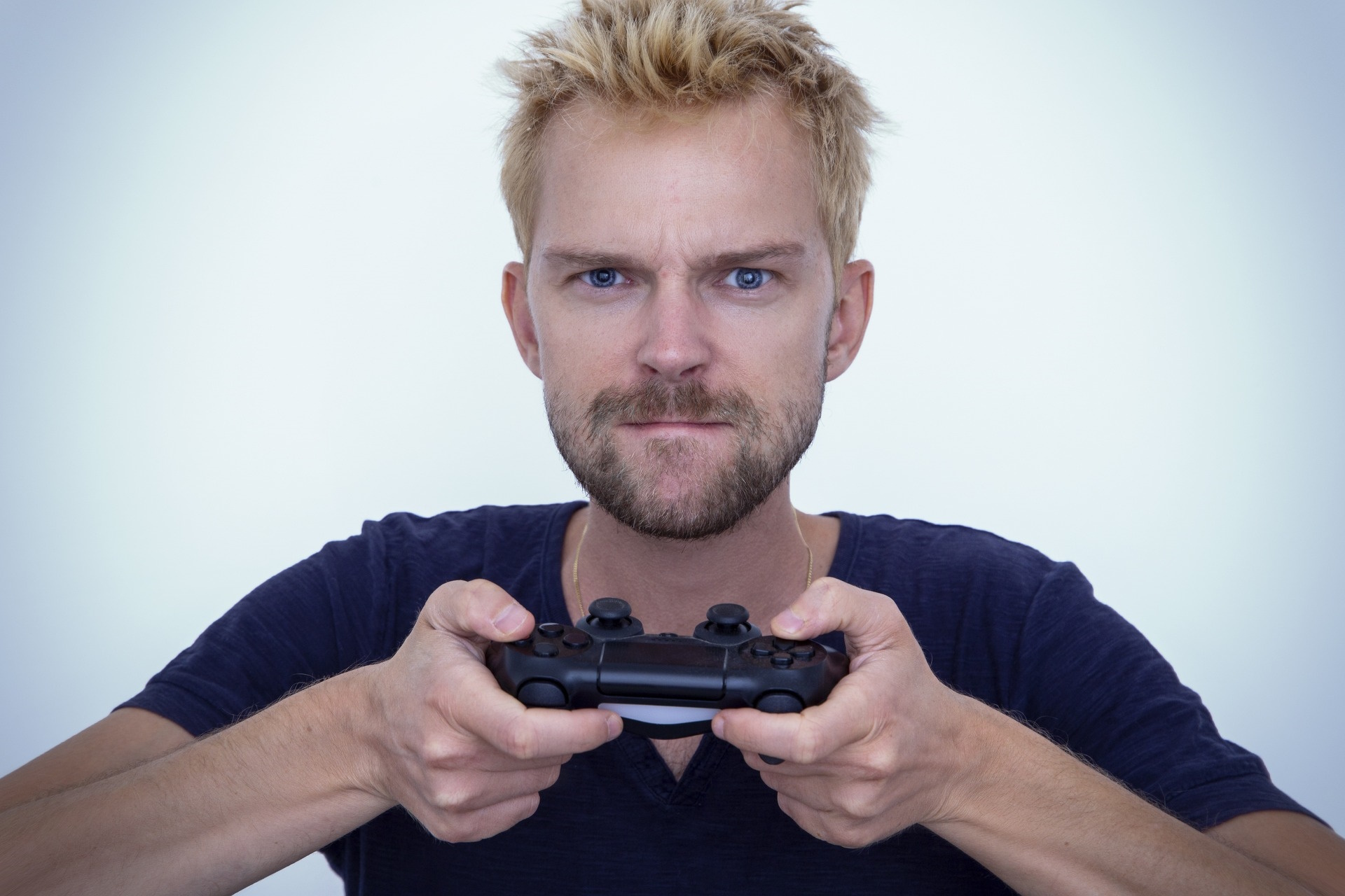 A stock photo of an angry man holding a PlayStation control pad.