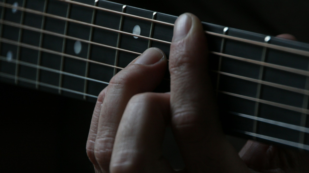 A photograph of a guitar chord being played.