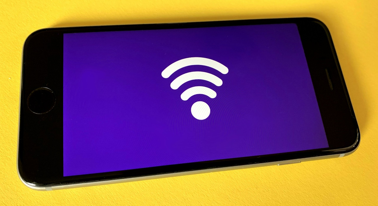 A photo of a smartphone displaying a wi-fi symbol on the screen.