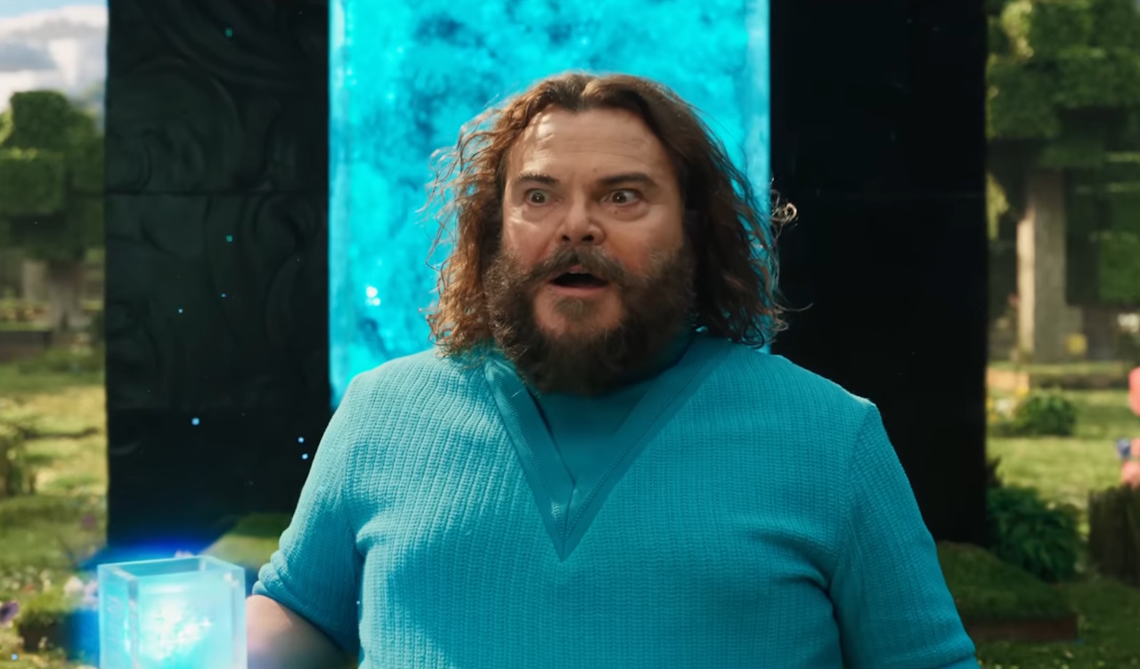 Still frame from the Minecraft Movie trailer showing Jack Black's character and a glowing portal.