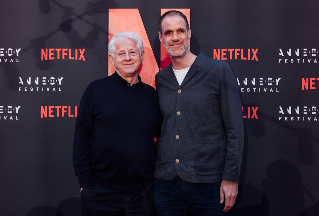 Photo of Richard Curtis and Simon Otto at an animation festival in front of a Netflix-branded banner.