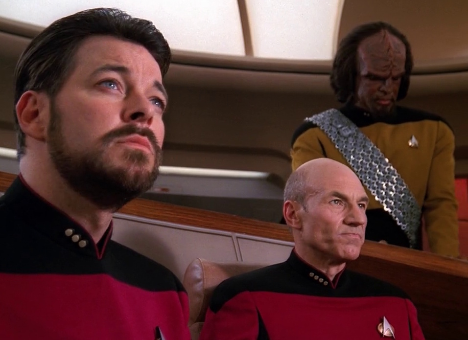 Still frame from Star Trek: The Next Generation showing Riker, Picard, and Worf on the bridge.