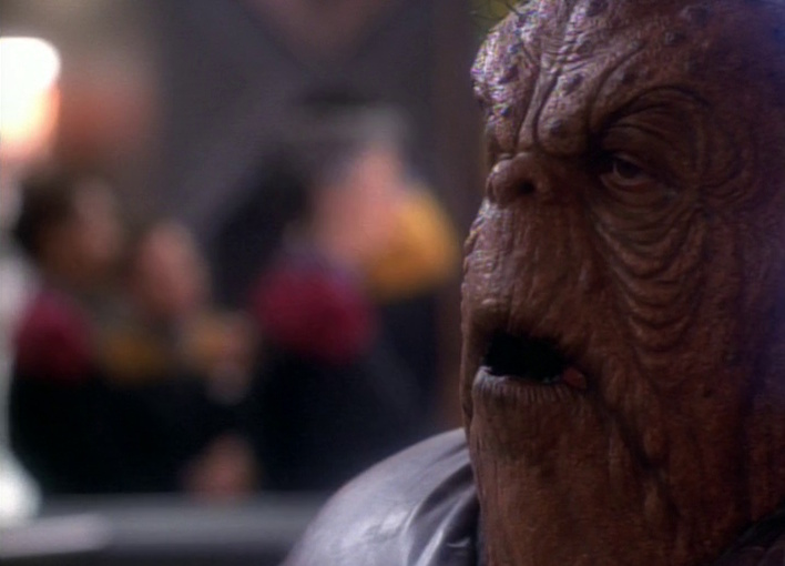 Still frame from Star Trek: Voyager showing Morn at Quark's bar.