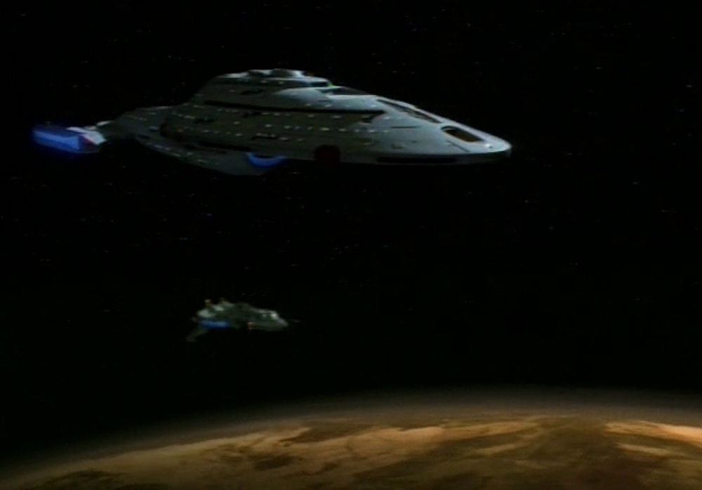 Still frame from Star Trek: Voyager showing the USS Voyager and the Maquis raider Val Jean in orbit of a planet.