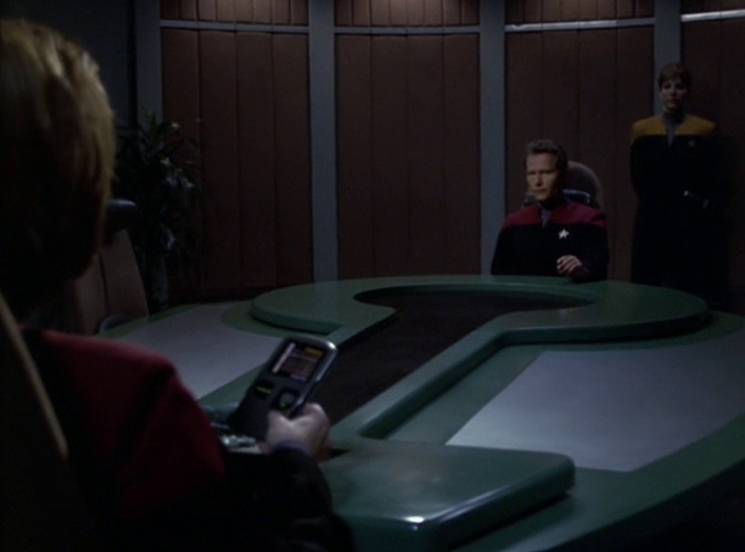 Still frame from Star Trek: Voyager showing Captain Janeway confronting Captain Ransom in the briefing room.