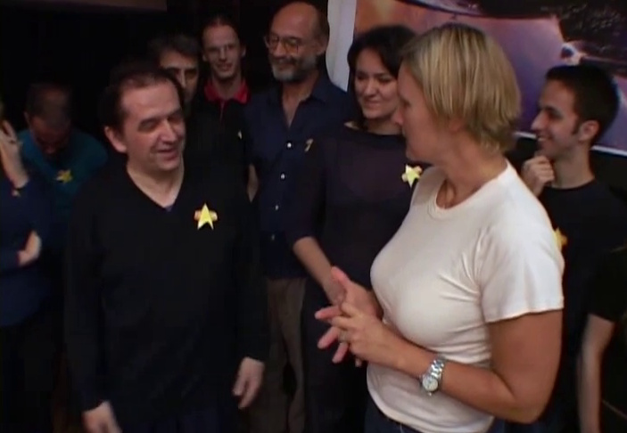 Still frame from Trekkies 2 showing Denise Crosby (the host) with a group of Star Trek fans.