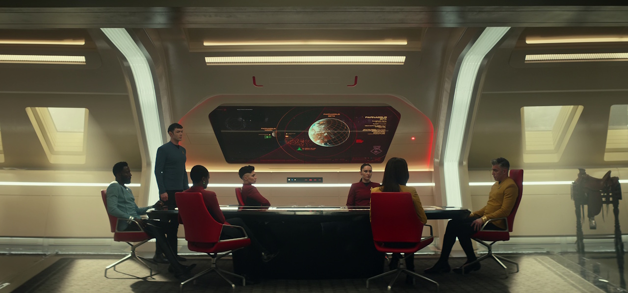 Still frame from Star Trek: Strange New Worlds Season 2 Episode 10 (2023) showing the senior officers in Pike's briefing room.