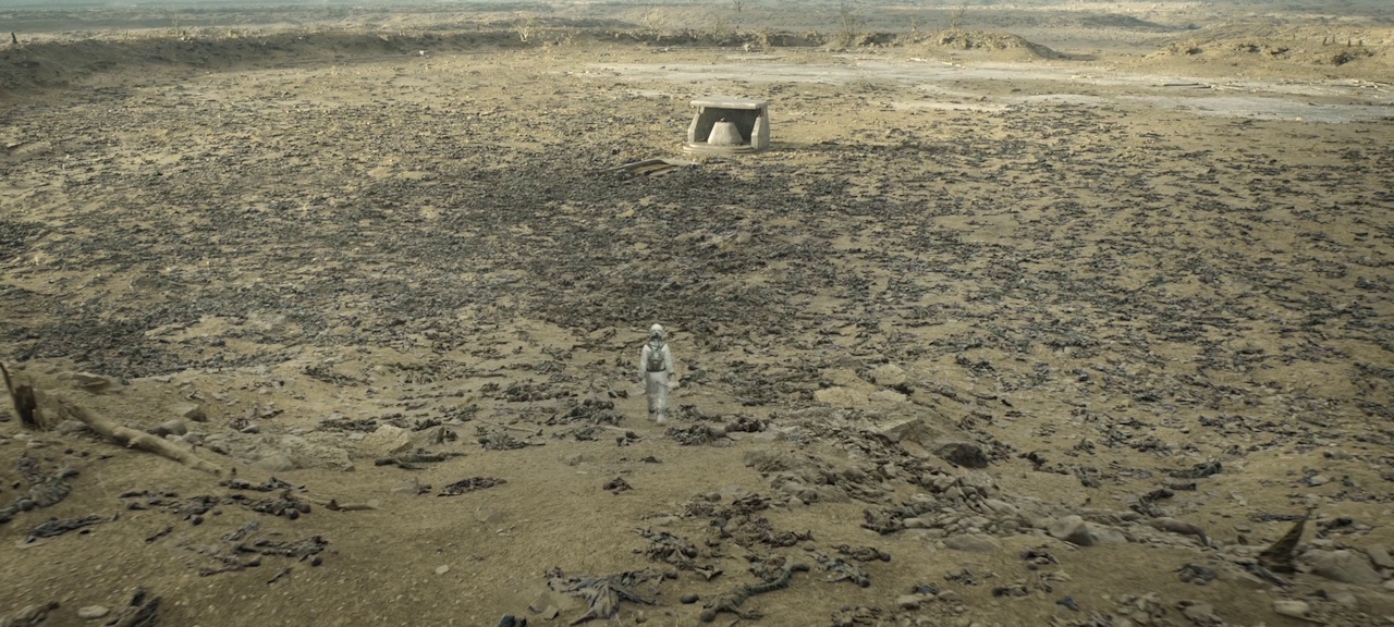 Still frame from Silo Season 2 (2024-25) showing Juliette walking through a field of dead bodies to reach the second silo.