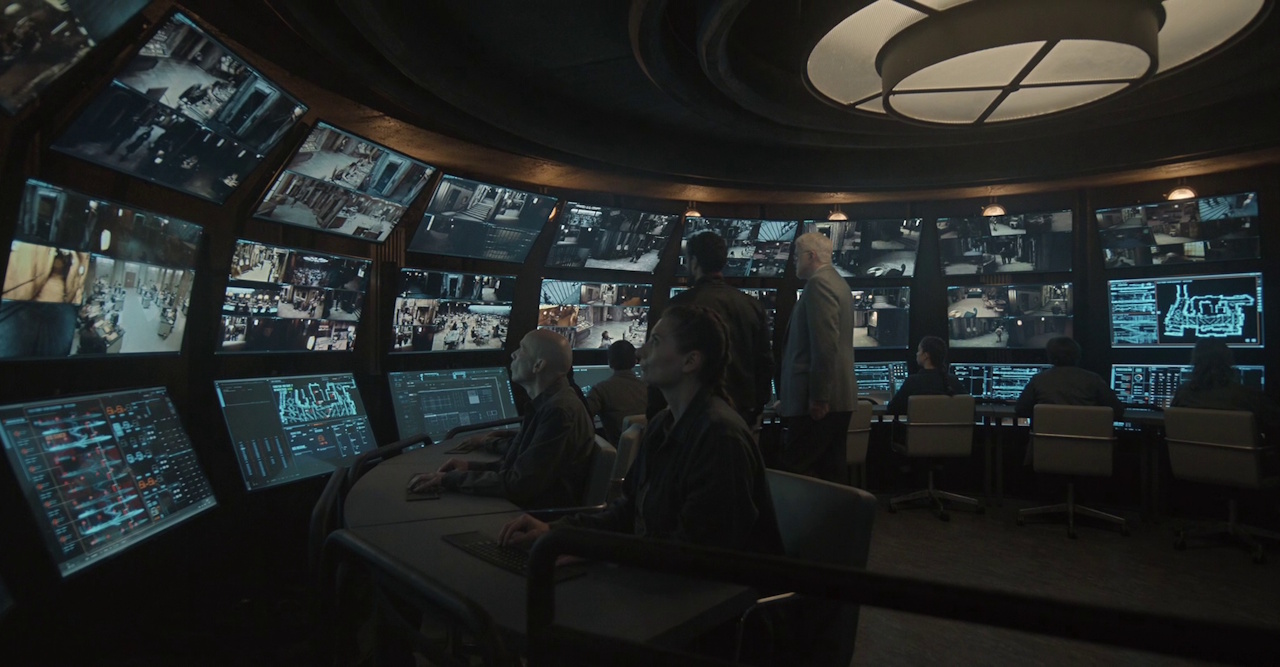 Still frame from Silo Season 2 (2024-25) showing Mayor Hollins in the surveillance room.