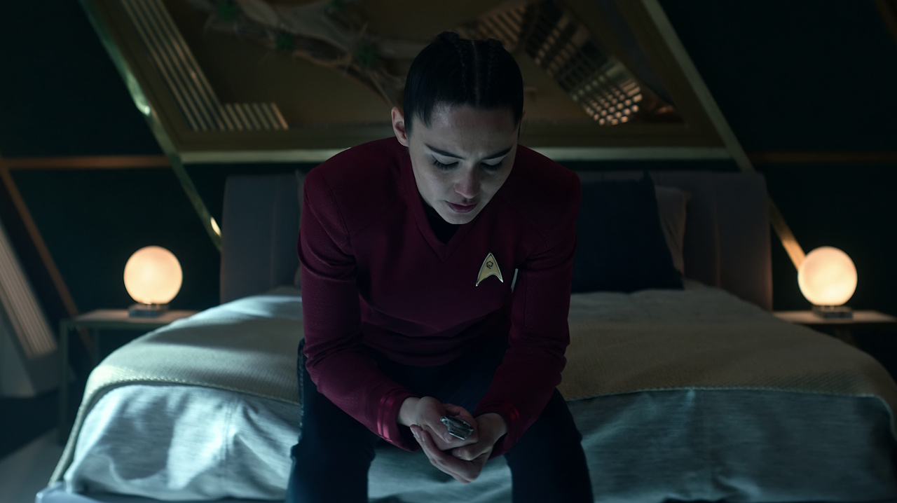 Still frame from Star Trek: Strange New Worlds Season 2 (2023) showing La'an sitting on her bed.