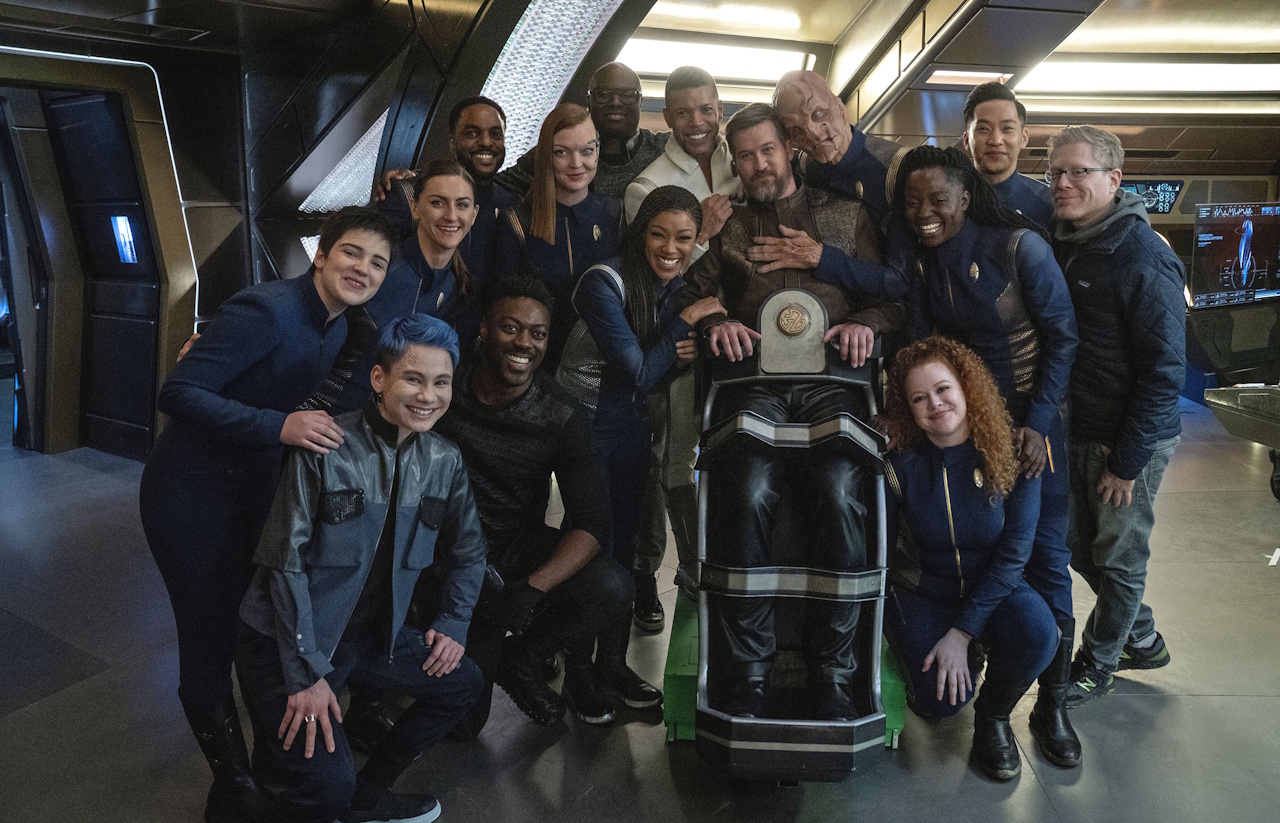Behind-the-scenes photo from Star Trek: Discovery's third season showing most of the main cast with guest star Kenneth Mitchell.