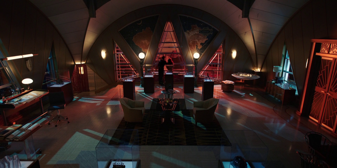 Still frame from Megalopolis (2024) showing Cesar and Julia looking out of the window of their office.