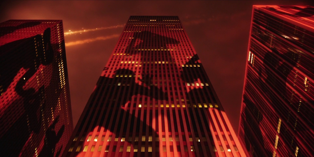 Still frame from Megalopolis (2024) showing figures projected onto skyscrapers.