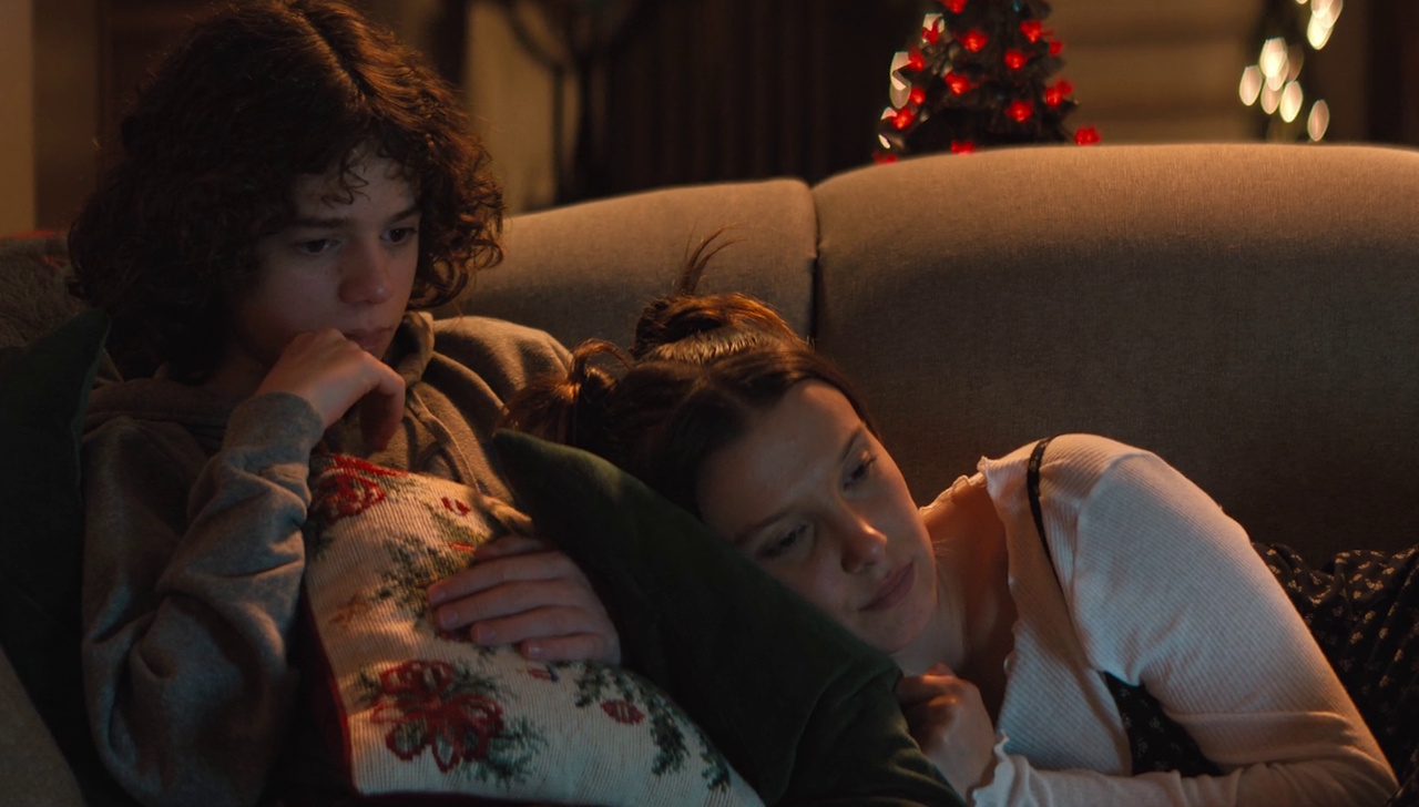 Still frame from The Electric State (2025) showing a flashback of Chris and Michelle.