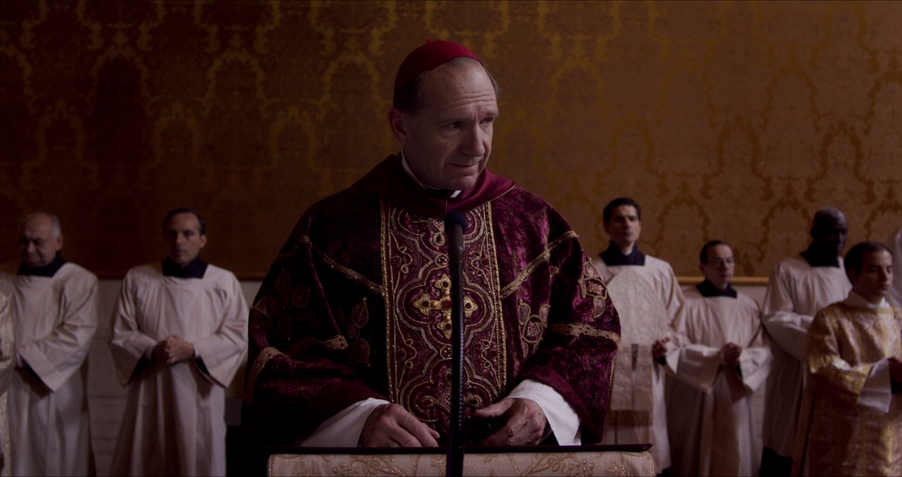 Still frame from Conclave (2024) showing Cardinal Lawrence delivering his homily.