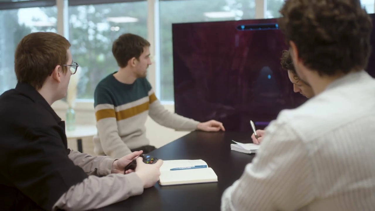 Still frame from the Oblivion Remastered presentation, showing four people playing the game in an office setting.