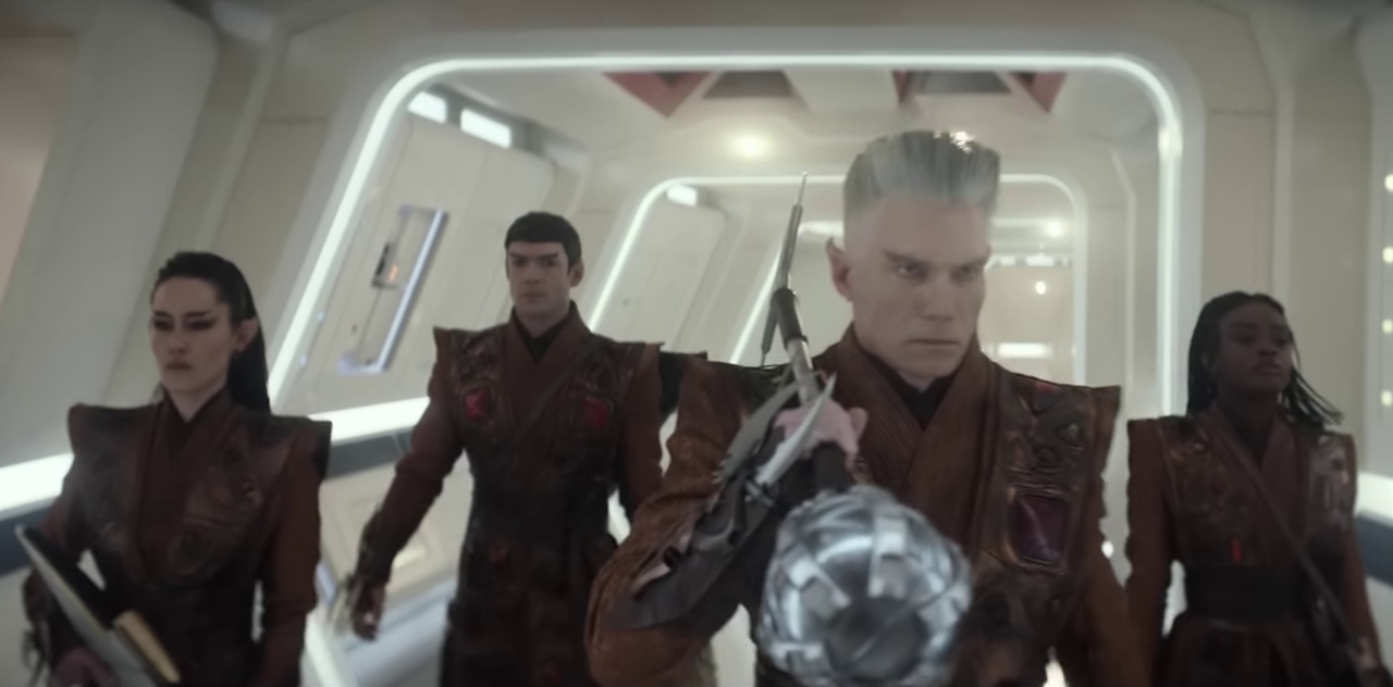 Still frame from the Star Trek: Strange New Worlds Season 3 trailer showing Pike, La'an, Uhura, and Spock in Vulcan costumes carrying Vulcan weapons.