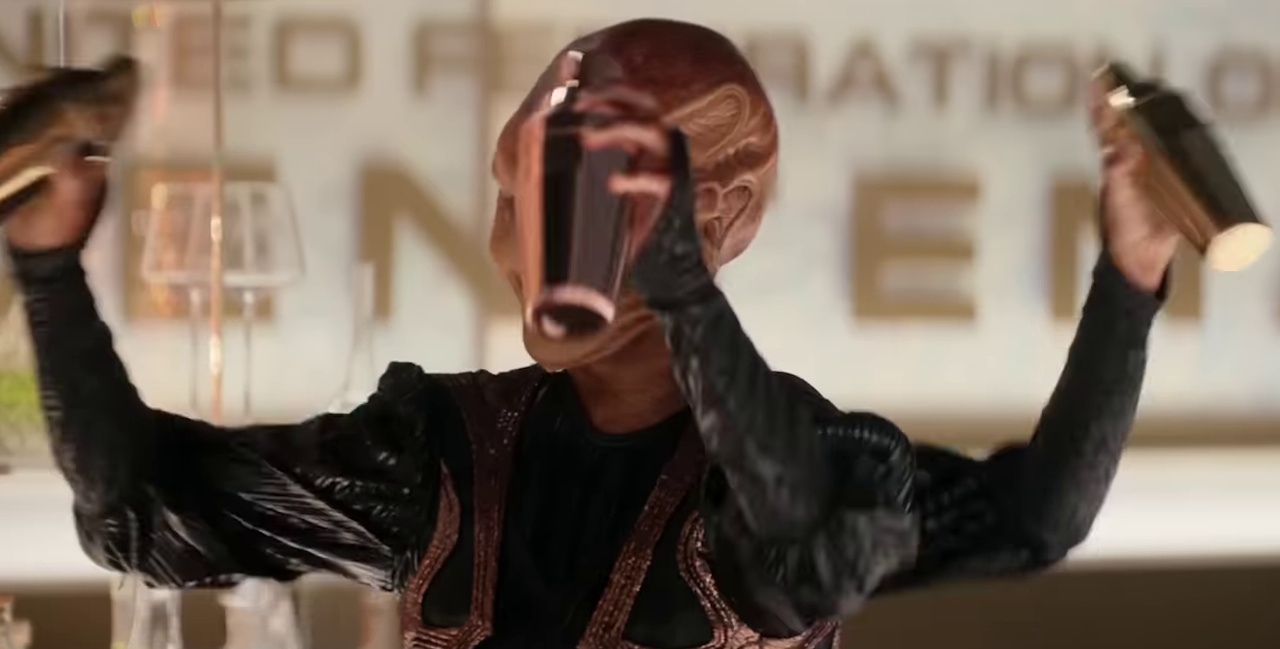 Still frame from the Star Trek: Strange New Worlds Season 3 trailer showing a three-armed alien character.