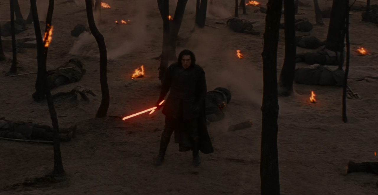 Still frame from Star Wars: The Rise of Skywalker (2019) showing Kylo holding his lightsaber, surrounded by trees and corpses.