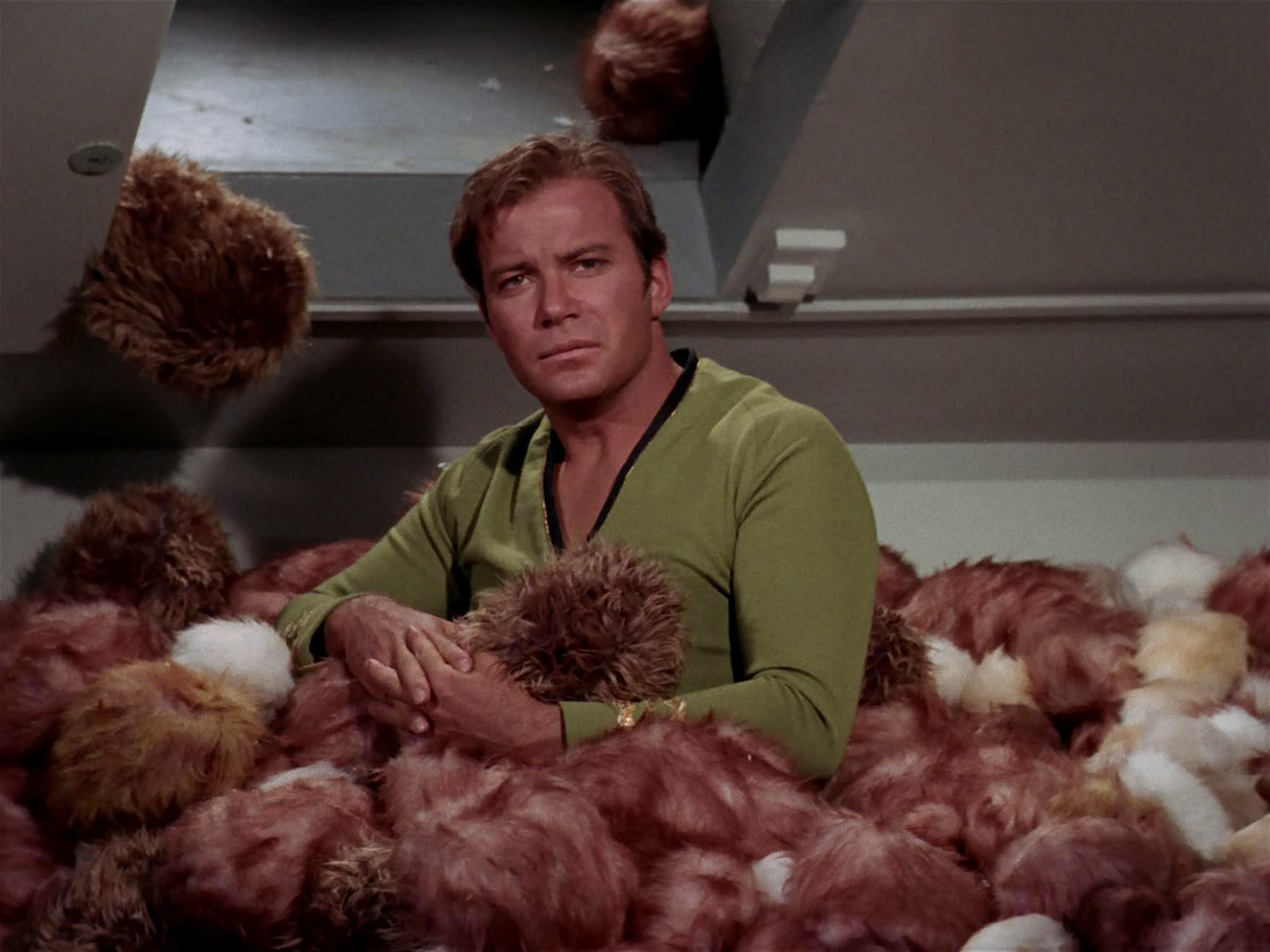 Still frame from Star Trek: The Original Series showing Kirk surrounded by tribbles.