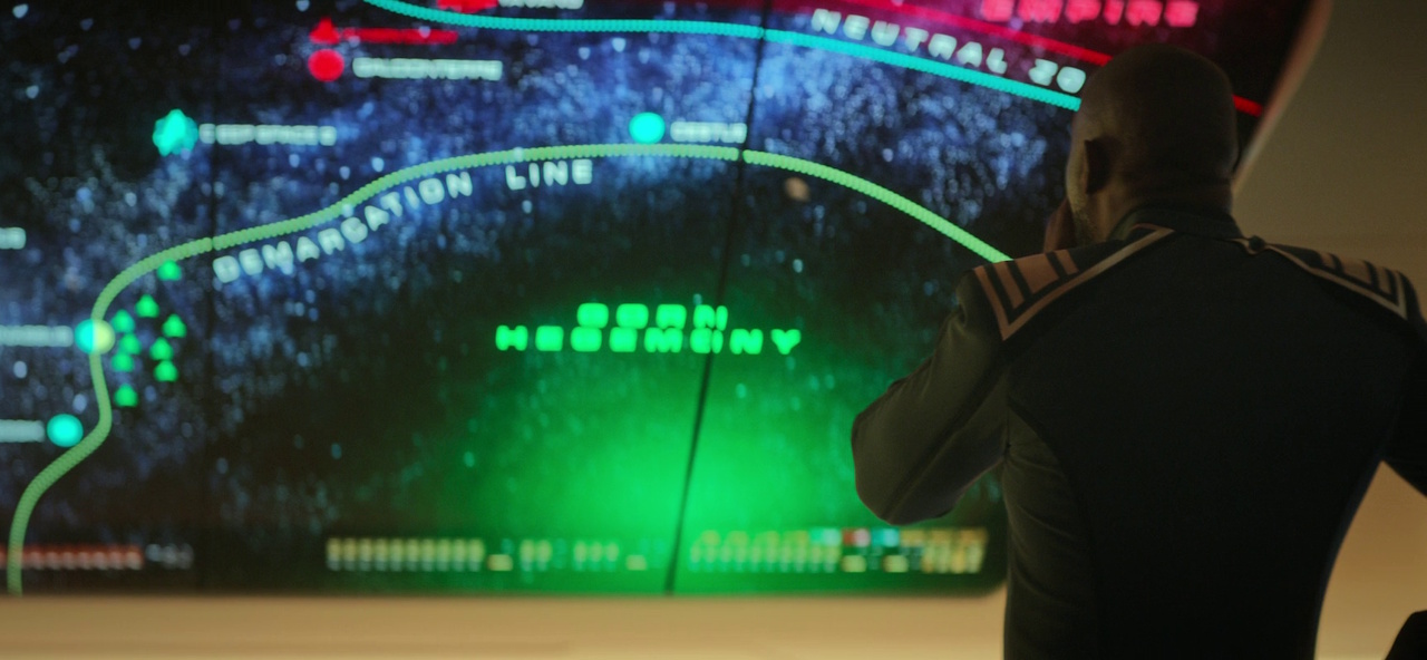 Still frame from Star Trek: Strange New Worlds 3x01: Hegemony, Part II, showing Admiral April consulting a map of Gorn space.