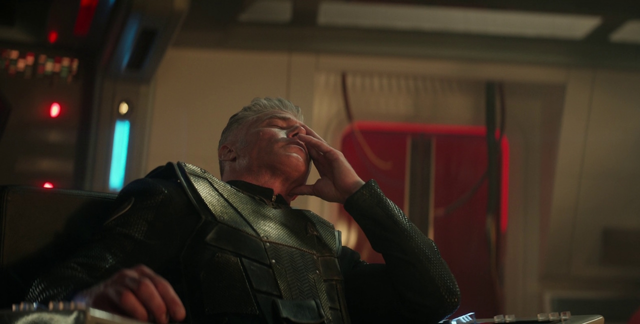Still frame from Star Trek: Strange New Worlds 3x01: Hegemony, Part II, showing Captain Pike in the captain's chair, with his face in his hands.