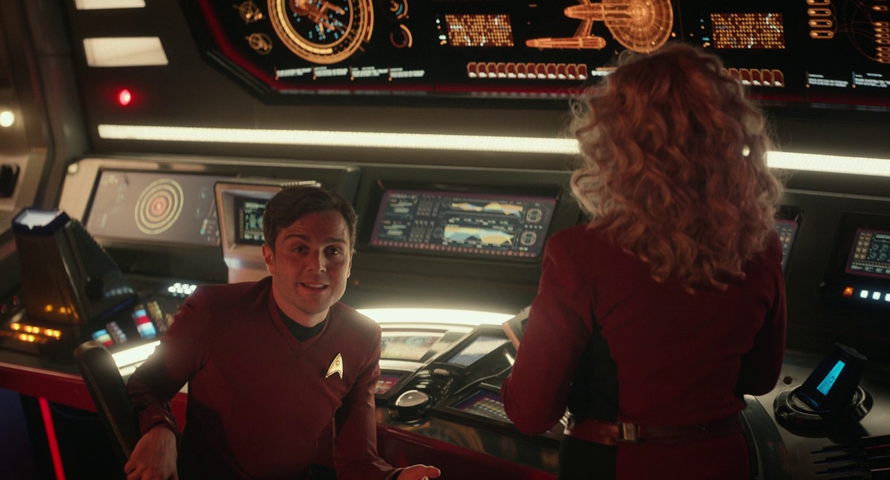 Still frame from Star Trek: Strange New Worlds 3x01: Hegemony, Part II, showing Scotty and Pelia on the bridge.