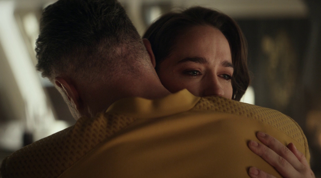 Still frame from Star Trek: Strange New Worlds 3x03: Shuttle to Kenfori, showing Captain Pike and Captain Batel hugging.