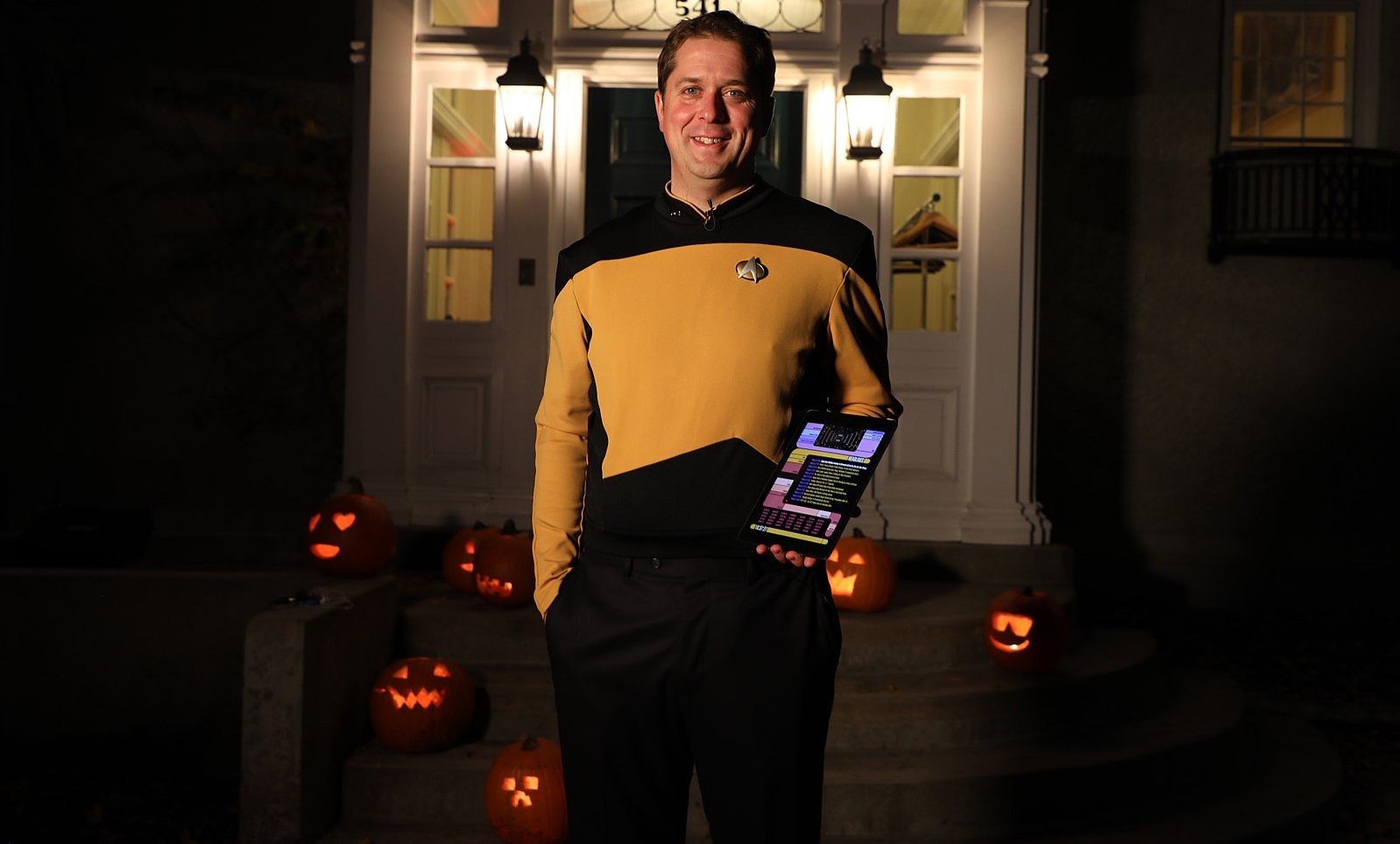 A stock photo of a man wearing a Star Trek costume at Halloween, surrounded by Jack-o-lanterns.