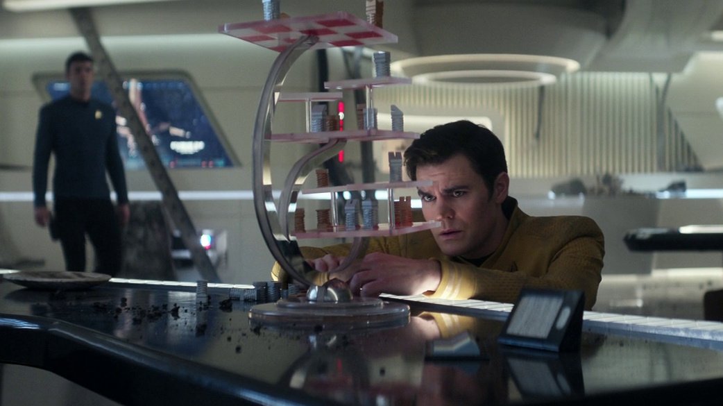 Still frame from Star Trek: Strange New Worlds 3x06: The Sehlat Who Ate Its Tail showing Spock approaching Kirk in the ready room.