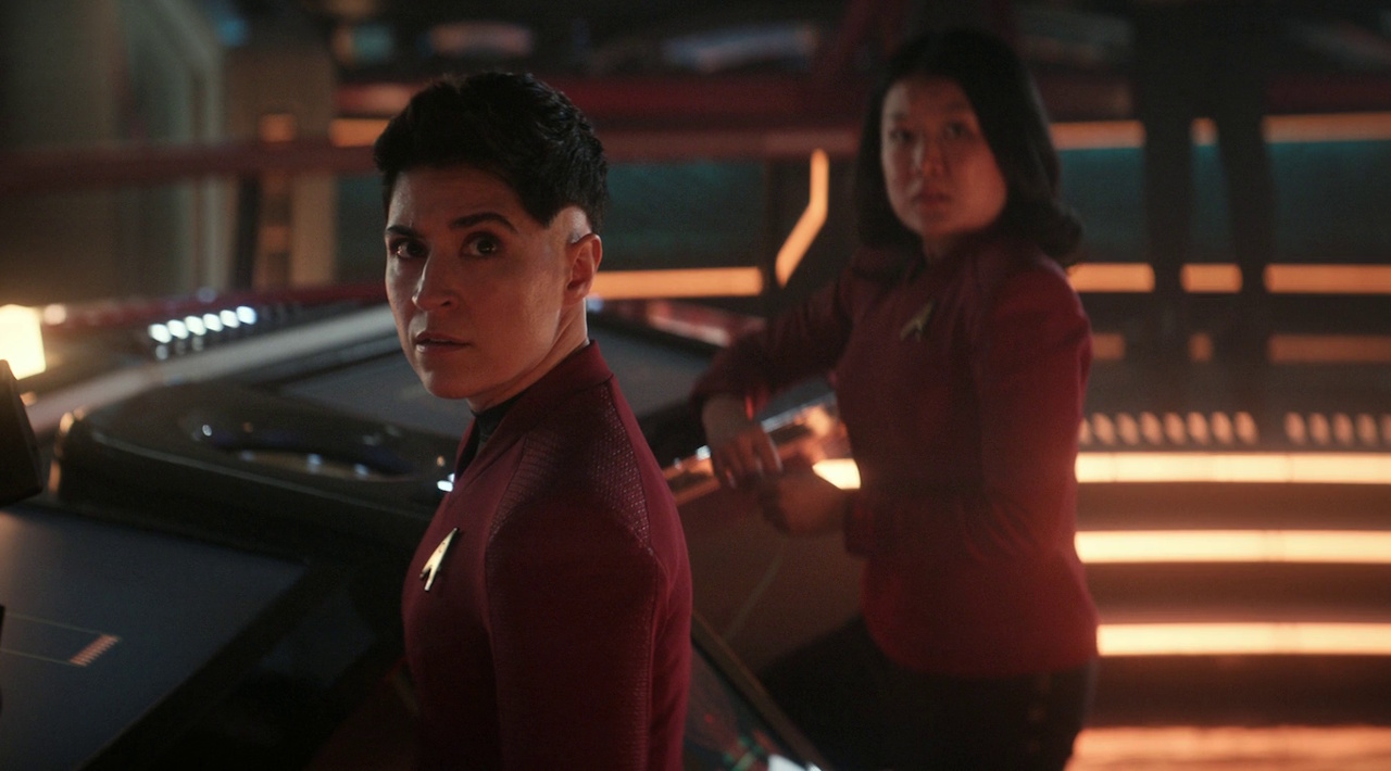 Still frame from Star Trek: Strange New Worlds 3x06: The Sehlat Who Ate Its Tail showing Ortegas and Mitchell on the bridge.