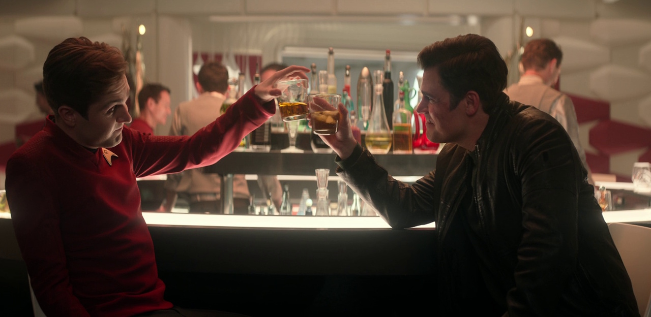 Still frame from Star Trek: Strange New Worlds, 3x08, Four-and-a-Half Vulcans showing Scotty and Kirk clinking glasses.