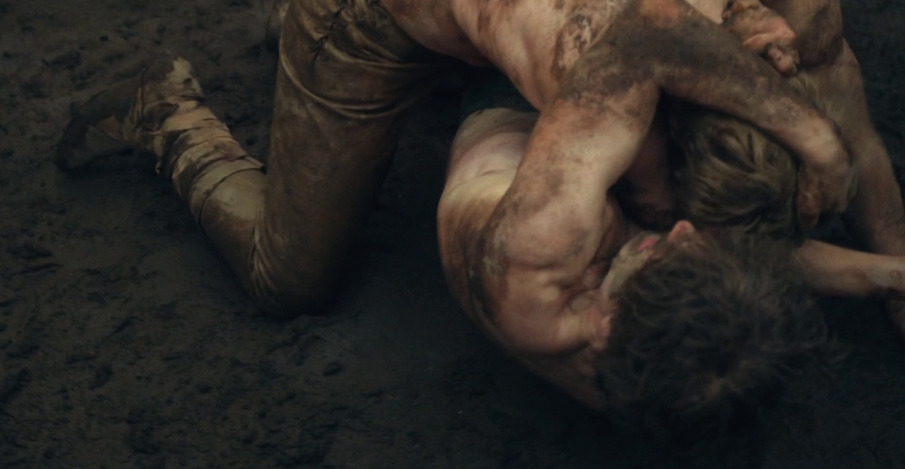 Still frame from King & Conqueror (2025) showing William and Harold wrestling in the mud.