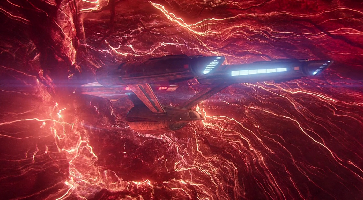 Still frame from Star Trek: Strange New Worlds 3x09: Terrarium, showing the USS Enterprise wedged in a wormhole.