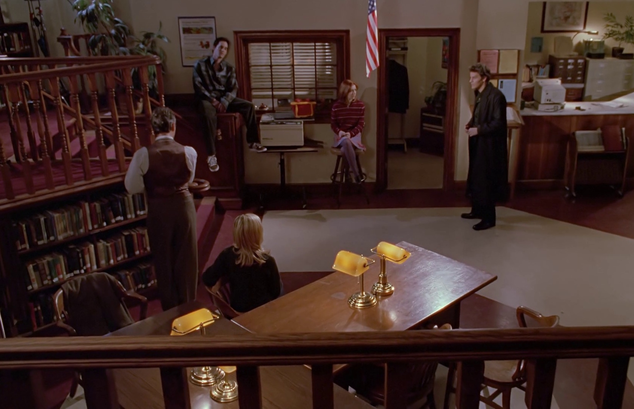 Still frame from Buffy the Vampire Slayer showing the gang in the library.