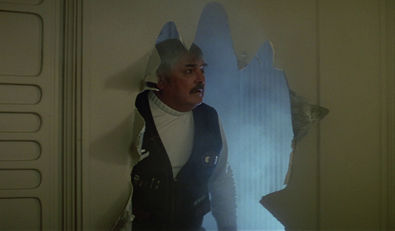 Still frame from Star Trek V showing Scotty breaking into the brig.