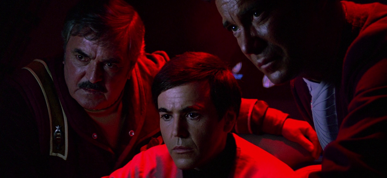 Still frame from Star Trek III showing Scotty, Chekov, and Kirk activating the self-destruct sequence.
