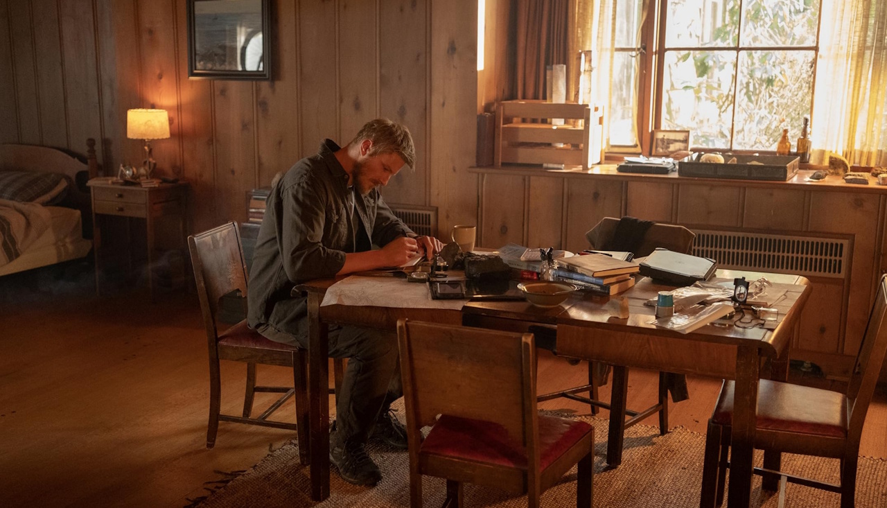 Promo image for Earth Abides showing the main character sitting at a table.