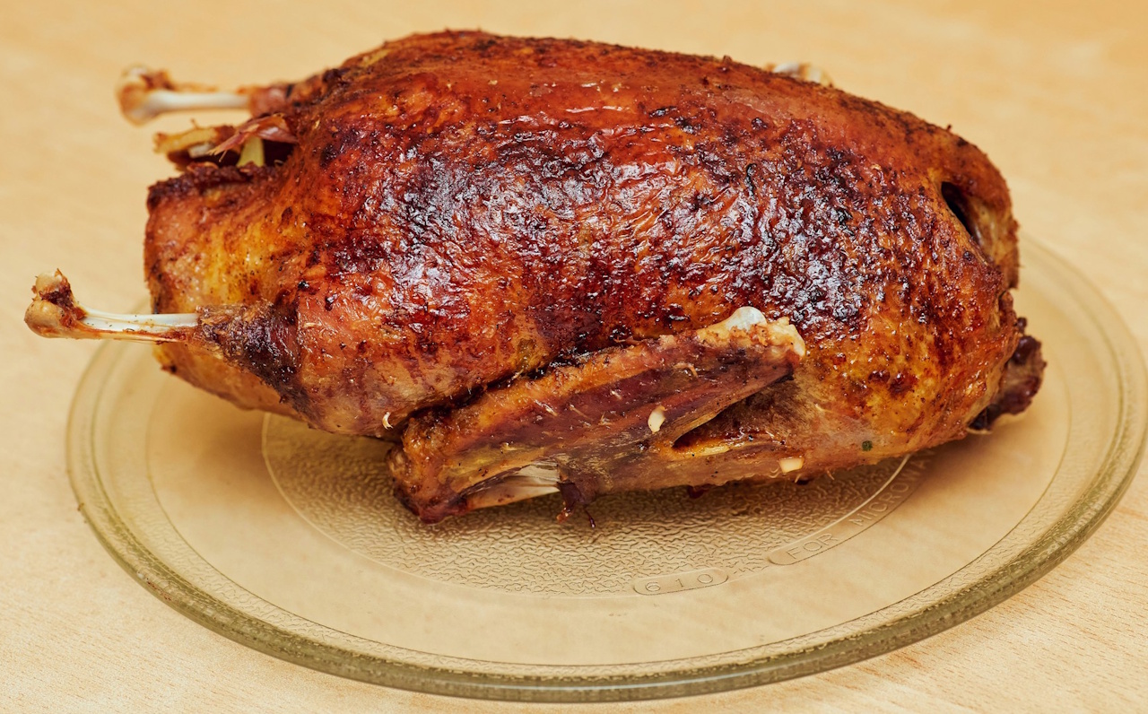 Stock photo of roast goose on a glass plate.